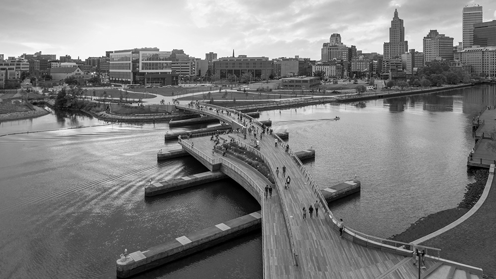 A black and white aerial photo of the Providence pedestrian bridge that crosses the Providence River on the footings of the old I-195 bridge.